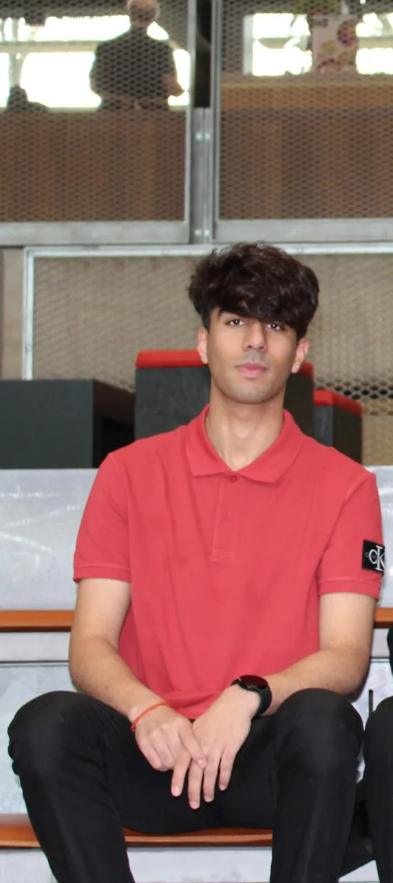 Taksh Dange, founder of Zenith Cite, seated in a red polo shirt